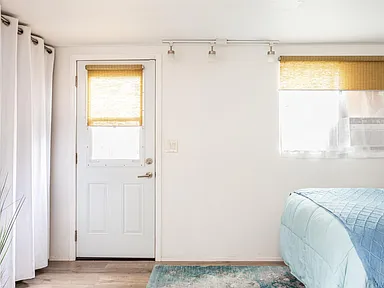 1957 trailer addition with white walls blue bed