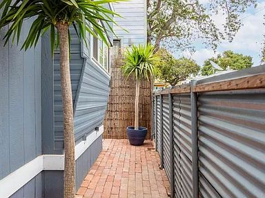 1957 trailer with blue house grey fence and brick floor