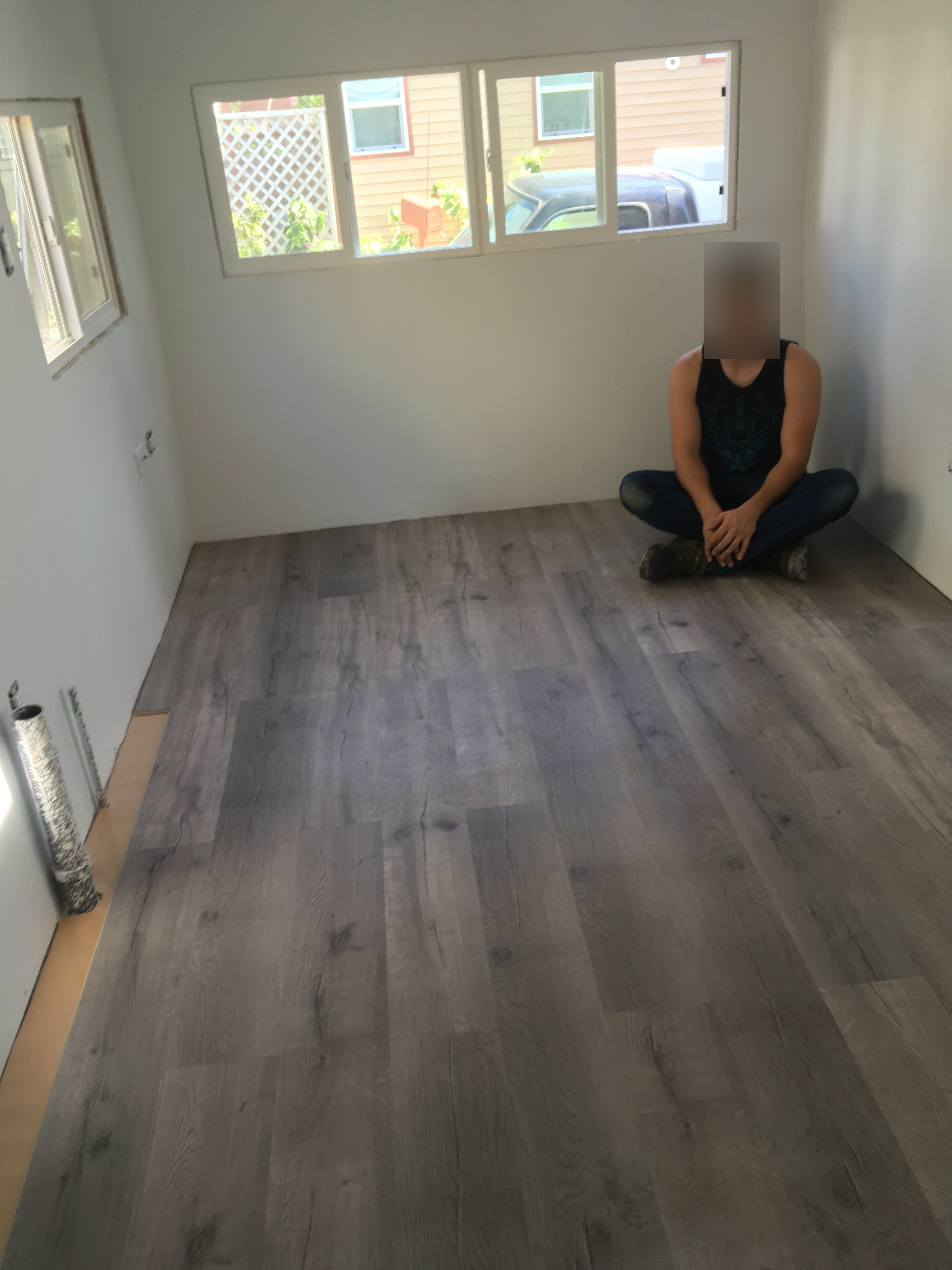 guy sitting on new flooring in 1957 trailer