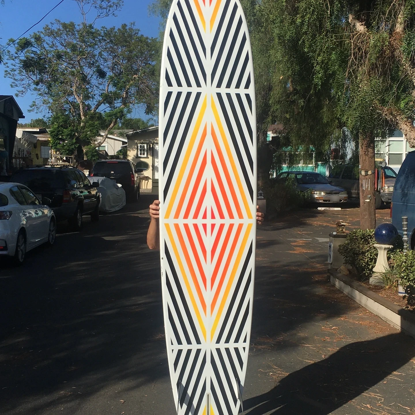 longboard surfboard painted with black white red yellow