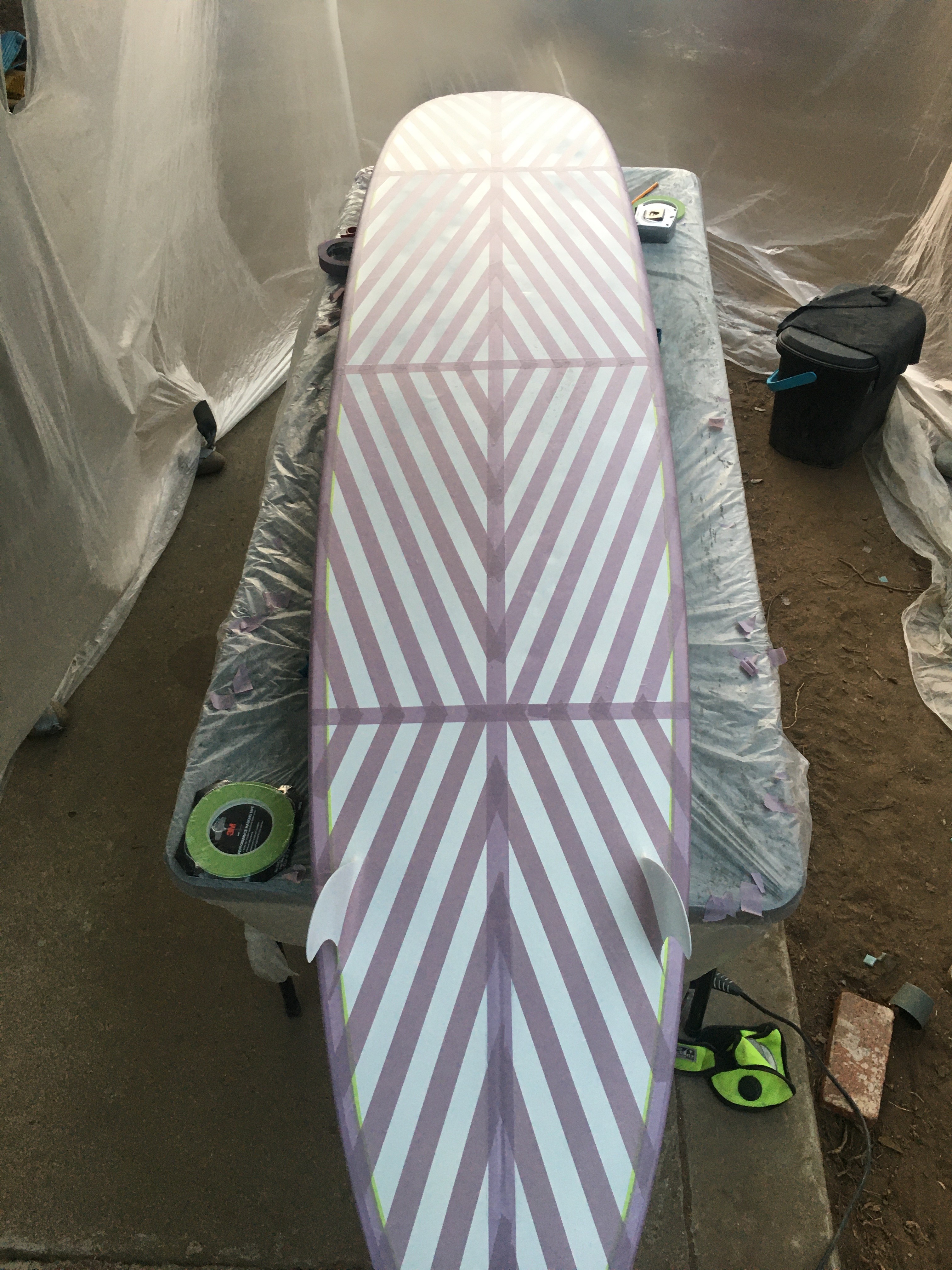 longboard surfboard painted with white and taped