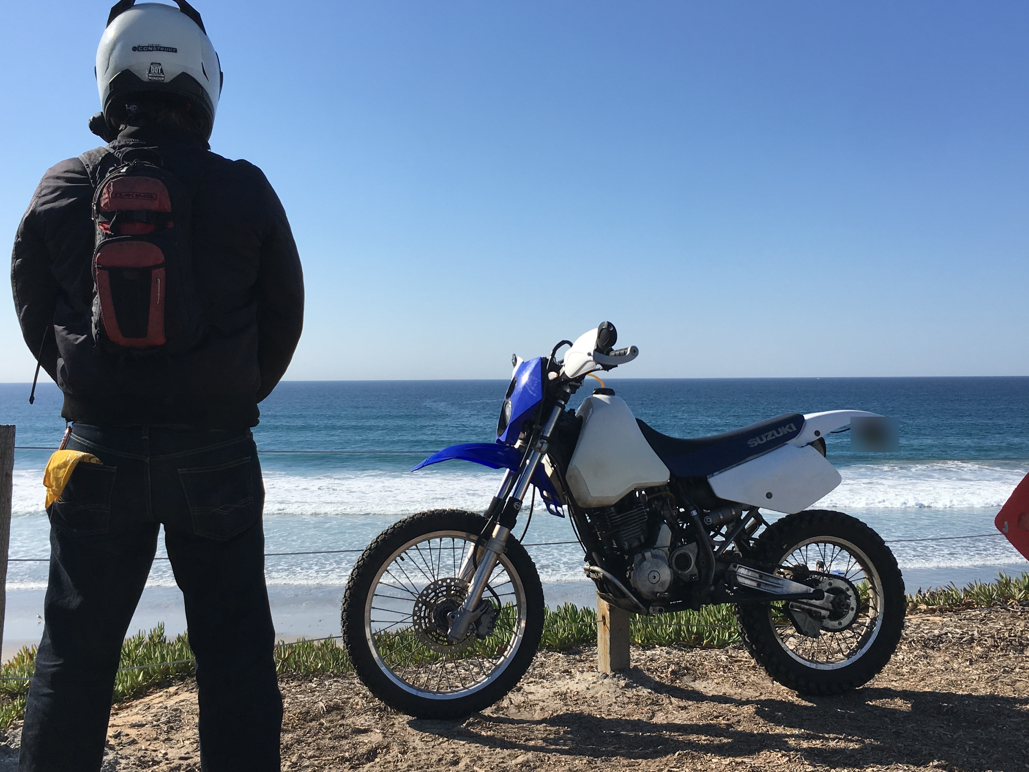 Guy standing next to 1998 DR350 at beach