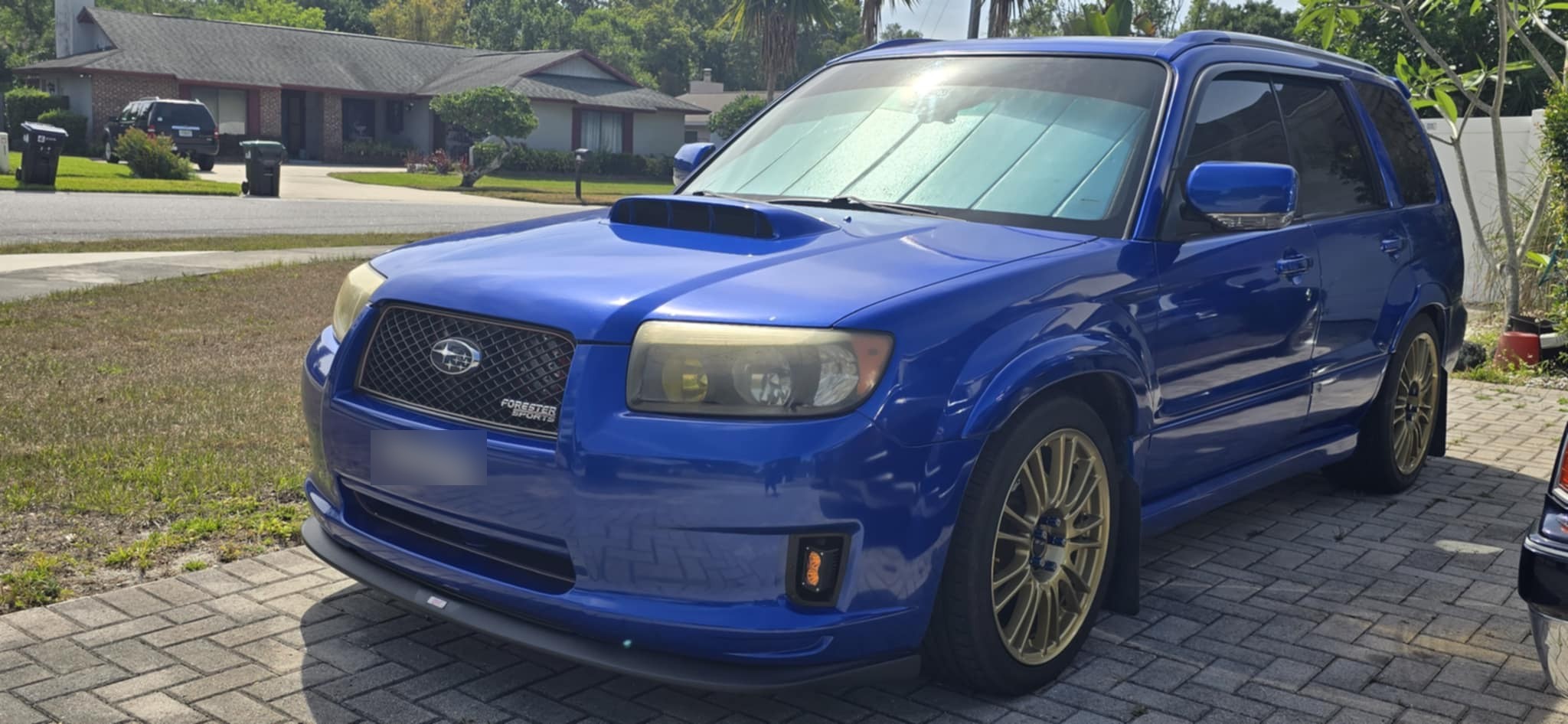 Blue Subaru Forester Sports in a driveway with the amber fog light kit installed