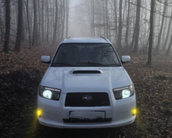 Head-on view of the white Forester showing both amber fog lights